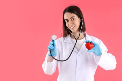 female trainee doctor with heart on pink background
