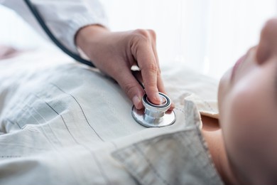 close up hands of asian physician doctor measure heart rate on patient. attractive beautiful medical therapist female practitioner examiner young woman lying down on bed in recovery room in hospital.