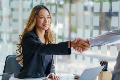 asian businesswoman shaking hands to congratulate success.