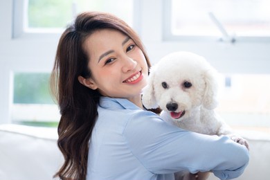 young asian woman playing with dog at home