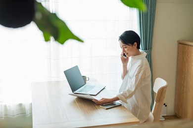 woman making a phone call while working remotely