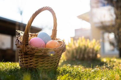 happy easter. basket with easter eggs in grass on a sunny spring day - easter decoration, banner, panorama, background with copy space for text.