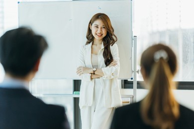 group of asian young modern people in smart casual wear having a brainstorm meeting while sitting in office background. business meeting, planning, strategy, new business development, startup concept.