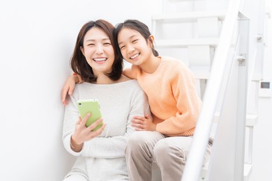 young asian mother and daughter,smart phone