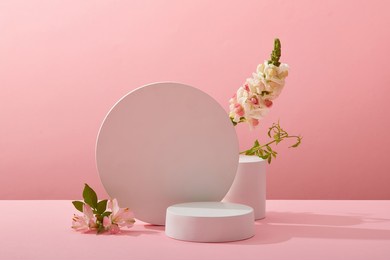 a front view of white podium decorated with flower and pink background with blank space for advertising 