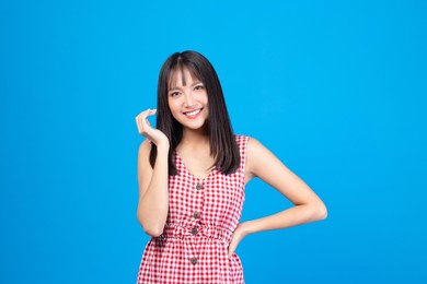 portrait of beautiful young asian girl model long hair in casual summer clothes smile, happy and enjoying in studio isolated on blue background.