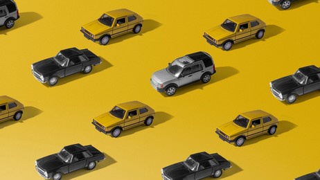 toy cars pattern on yellow background. minimal concept of car market crash