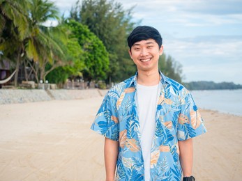 portrait asian man tourism cross arm happy smiling on the beach with beautiful ocean background copy space