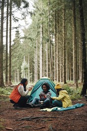 group of diverse young female friends relaxing together at their campsite in a forest 