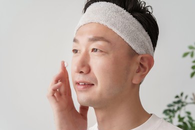 middle man applying cream to his face