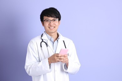 the young adult asian physician standing on the purple background.