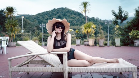 portrait of a beautiful asian woman happy relaxes around a swimming pool in hotel resort for holiday vacation, holiday concept.