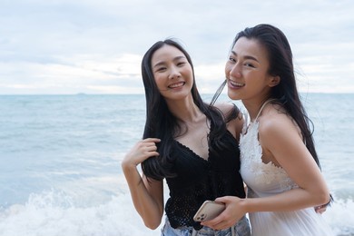 young asian woman friends on vacation at the beach