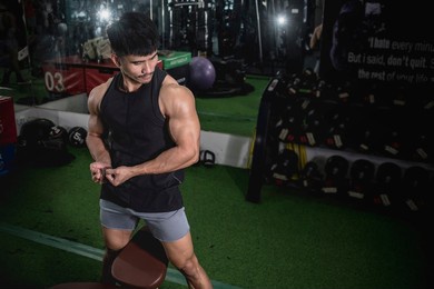 a fit man flexes his biceps and feels the pump after a vigorous arm workout. isometeric hold at the gym.