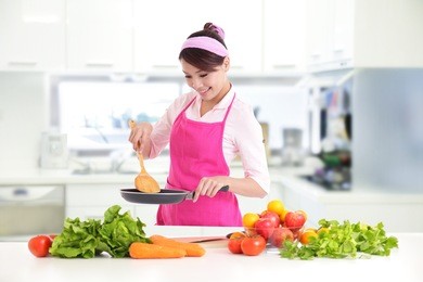 happy smiling woman in kitchen with fresh produce vegetables preparing for a healthy meal, asian
