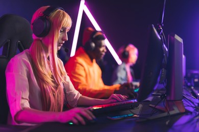 focused professional e-sport gamer girl with headset streaming online video game on pc. high quality photo