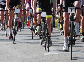 many cyclists pedaling fast on bicycles during road cycling race