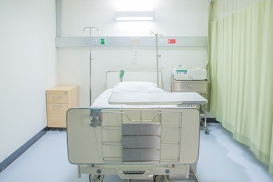 a hospital room with bed and chair