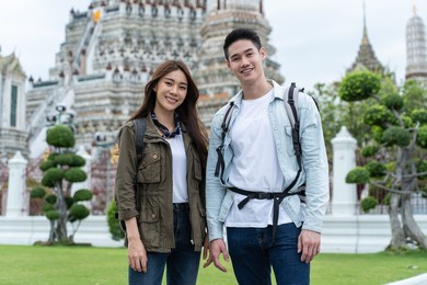 portrait of asian attractive romantic couple standing in the temple. young new marriage man and woman backpacker tourist look at camera and enjoy spending time on holiday for honeymoon trip together.