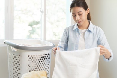 laundry household work concept, asian woman working on fresh clean clothes.