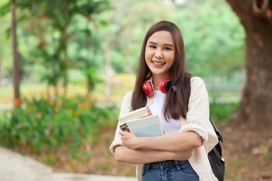portrait of a happy asian female student in the garden. distance education educational concept. learning concept. online education concept. asian beautiful student