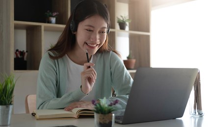 curious asian students while studying online on the internet and laptop video conferencing teachers at home.