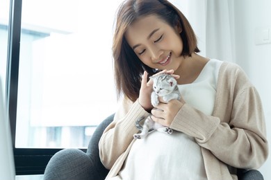 portrait of young asian pregnant with kitten