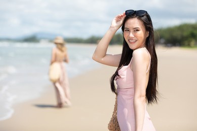portrait young asian woman smiling and enjoy travel on the beach