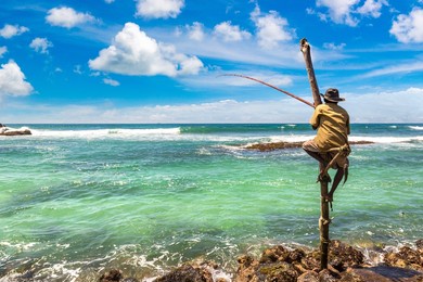 local fisherman fishing in traditional way at the beach in sri lanka