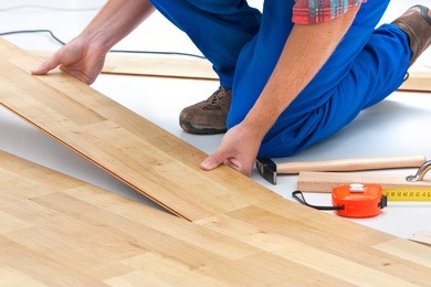 carpenter worker installing laminate flooring in the room