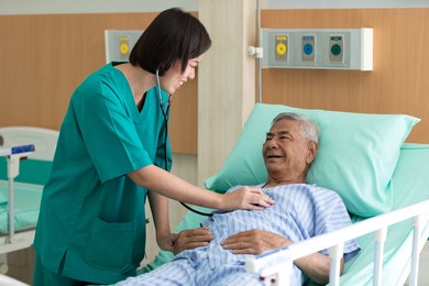 doctor using stethoscope and examining to elderly patient at waiting room in hospital 