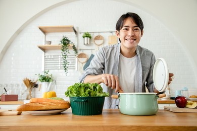 handsome asian man prepares breakfast after all the ingredients are cooked in the kitchen. health care concept and eating healthy food. good skin and good health