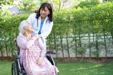 doctor help and care asian senior or elderly old lady woman patient sitting on wheelchair at park in nursing hospital ward, healthy strong medical concept.