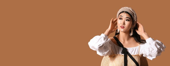 portrait of stylish asian woman on beige background with space for text