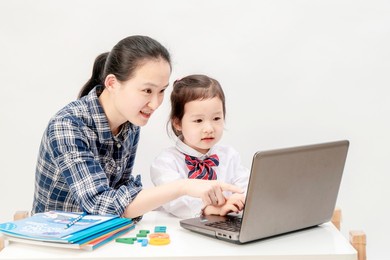 mother and little girl are learning english letters