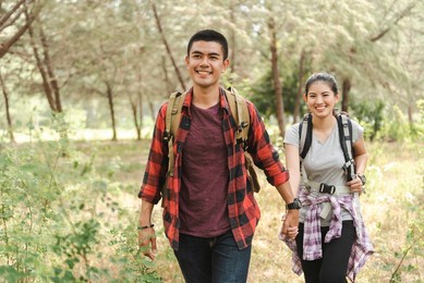 asian tourist couple walking hand in hand in the forest