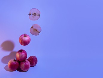 a composition of levitating red apples. a postcard for the summer season in neon blue with a place for text. healthy eating, veganism