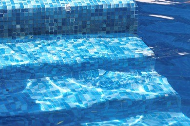 outdoor inground residential swimming pool in backyard with hot tub 