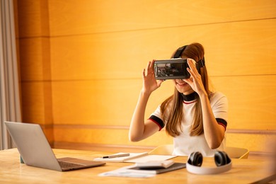 cheerful caucasian woman wearing vr glasses at home girl having fun with glasses with hands making imaginary gestures on the device.
