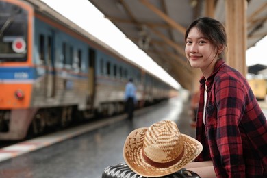 young asian woman traveler backpack waiting railway at train station, summer holiday and travel concept
