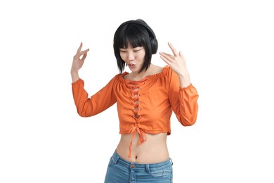 young asian woman listening music with headphones and dancing, isolated on white background.