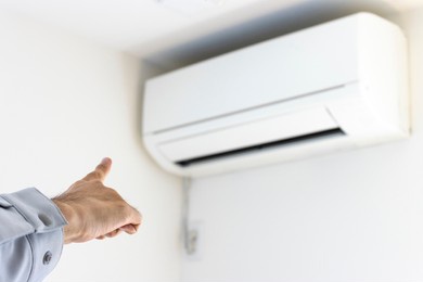 man's hand checking the air conditioner