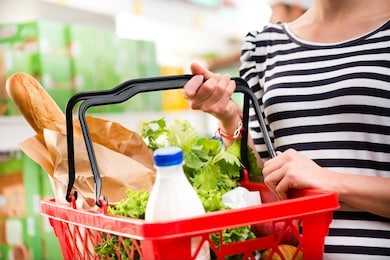 woman shopping at store with shopping basket.