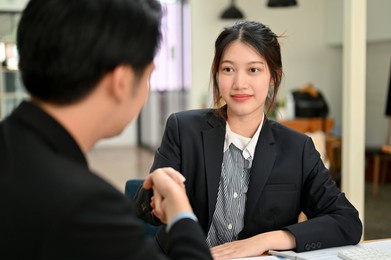 elegant asian businesswoman shaking hands with successful and professional businessman to agree with the business agreement contract.