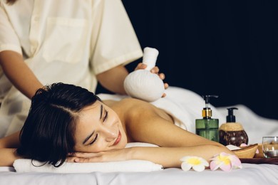 happy relaxing asian girl at beauty spa treatment. beauty young asian woman recieving massage at spa, massager's hands on the woman's shoulder spa concept. young woman with glow, and perfect skin.