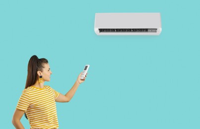 happy woman for comfort during summer heat uses modern air conditioner, isolated on turquoise background. smiling millennial woman in yellow t-shirt uses remote control to turn on air conditioner.