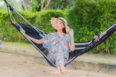portrait beautiful young asian woman sit on hammock swing around beach sea ocean in holiday vacation