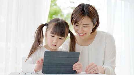 asian mother and daughter using tablet computer