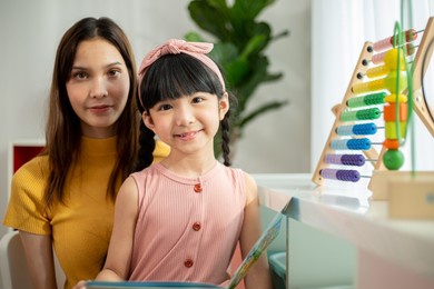 asian family read a book together. happiness people in living room.