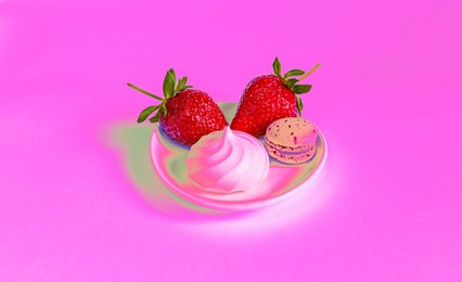 bright fresh strawberries, sweet marshmallow and macaroon in plate on neon pink background